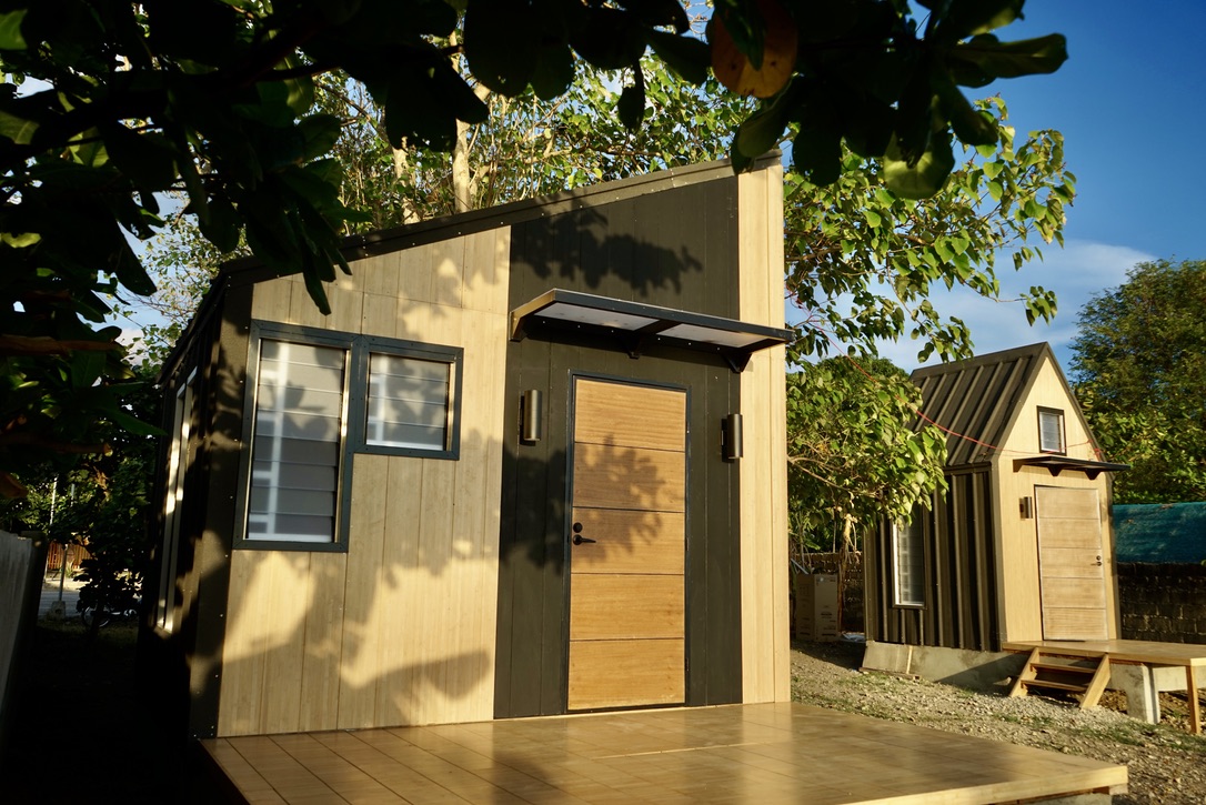 The front of a single-story ShelterTech building, two windows (left) with a door (right).