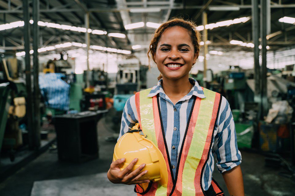 Person smiles holding construction hat