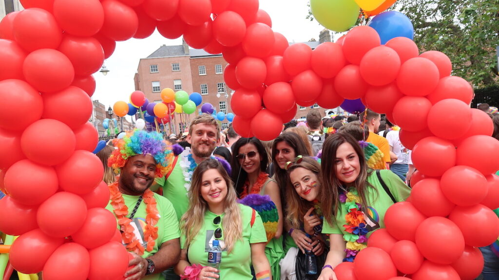 Members of Autodesk Pride Network stand under a heart-shaped balloon arch during the Pride parade