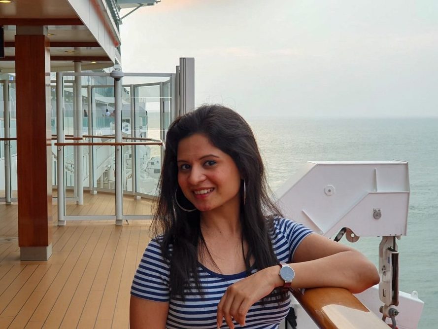 Kaveri Joshi poses near a body of water with her arm on a railing.