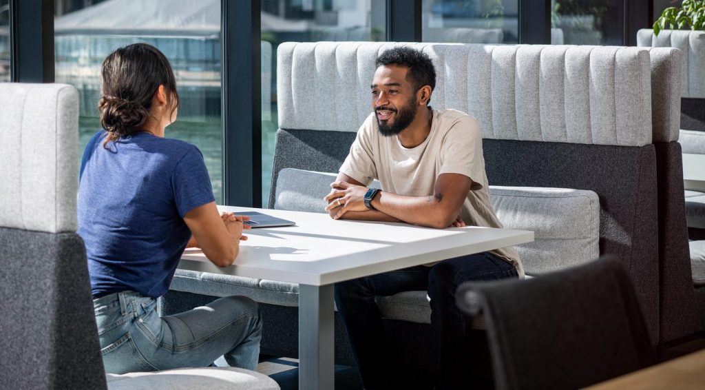 a man and woman having a discussion in a restaurant booth