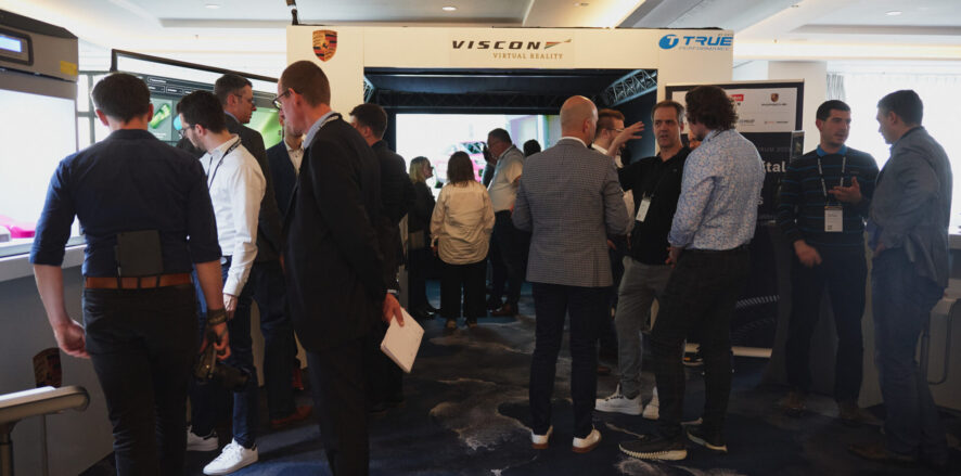 Group of people standing at an exhibition of technology booths.