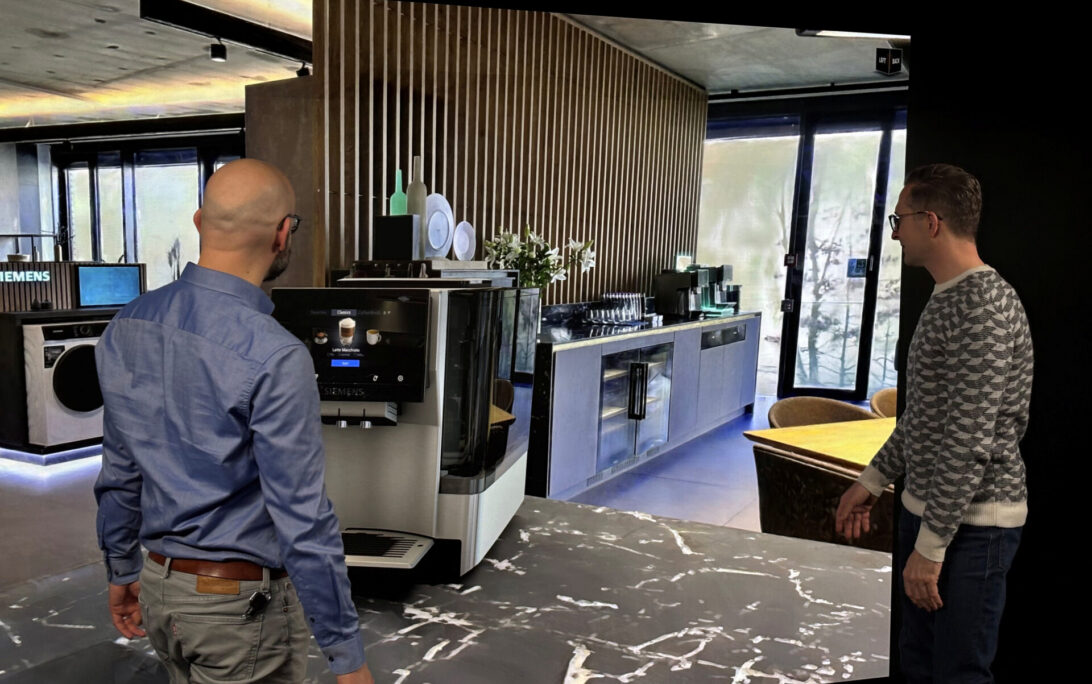 Two designers review a product in a Gaussian splat environment on a powerwall using Autodesk VRED.