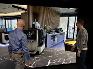Two designers review a product in a Gaussian splat environment on a powerwall using Autodesk VRED.