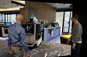 Two designers review a product in a Gaussian splat environment on a powerwall using Autodesk VRED.
