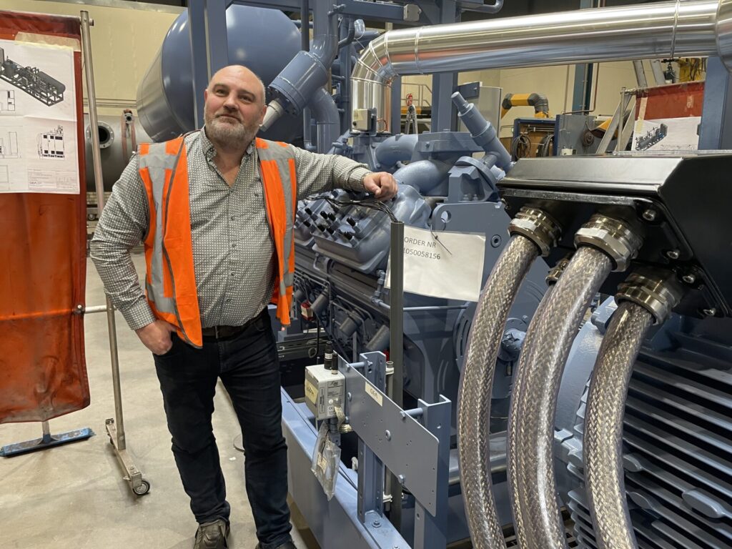 Man standing beside industrial equipment in a factory