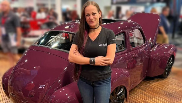 Bogi Lateiner standing in front of the Iron Maven car at SEMA