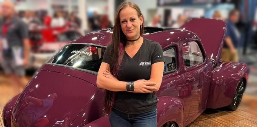 Bogi Lateiner standing in front of the Iron Maven car at SEMA
