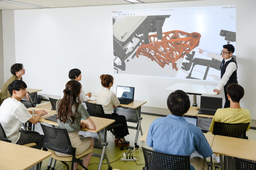 Instructor at front of classroom in front of Fusion 360 students at the Nihon Kogakuin College of Hachioji in Tokyo, Japan.