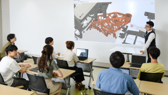 Instructor at front of classroom in front of Fusion 360 students at the Nihon Kogakuin College of Hachioji in Tokyo, Japan.