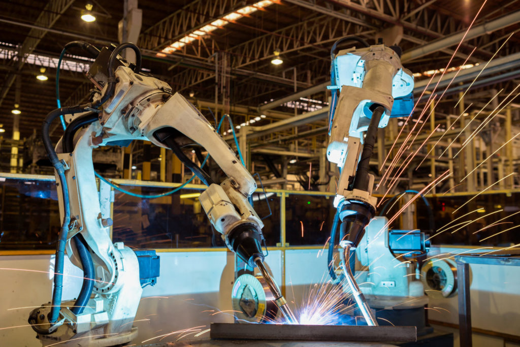 Team industrial robots welding in an automotive factory.