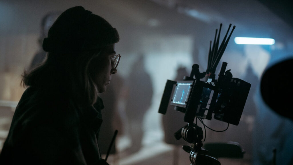 A director of photography looks at production footage on a monitor