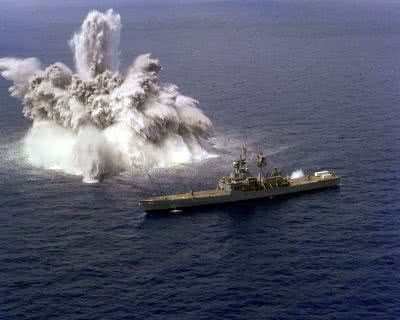 aircraft carrier near an explosion in the water